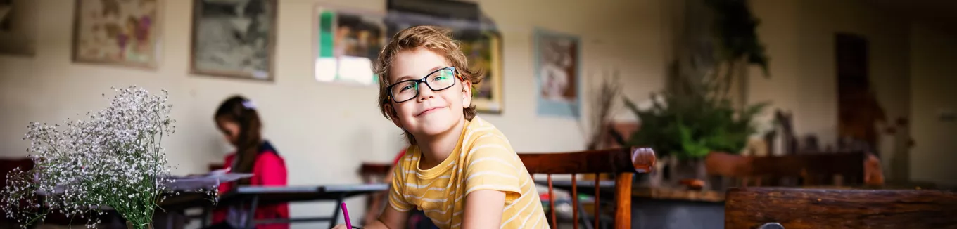 dítě s brýlemi v lavici na základní škole