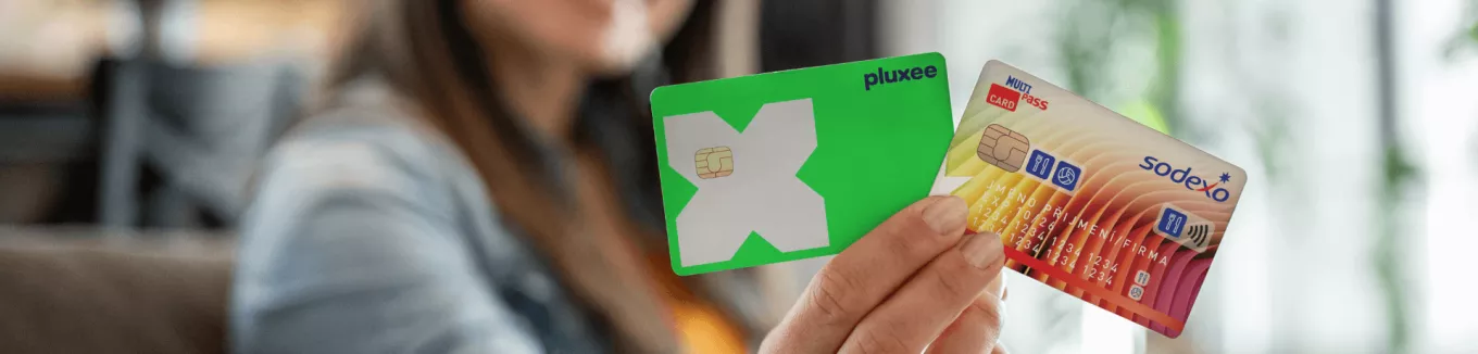 Ruka držící plastové benefitní karty Pluxee a Sodexo 