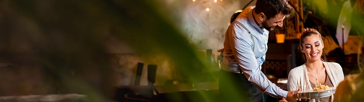 čísník obsluhující v restauraci