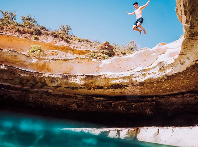 chlapec skákající do moře