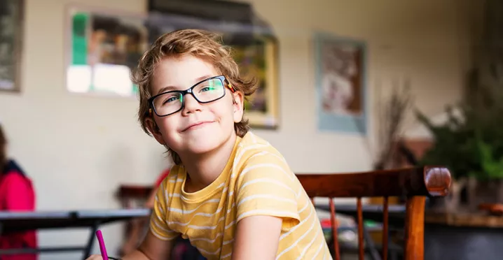 dítě s brýlemi v lavici na základní škole