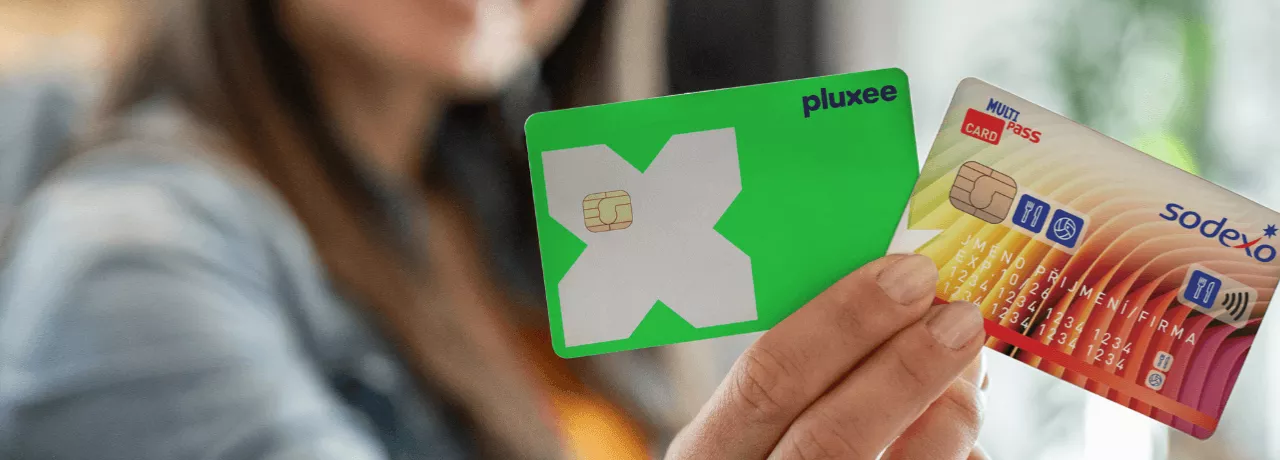 Ruka držící plastové benefitní karty Pluxee a Sodexo