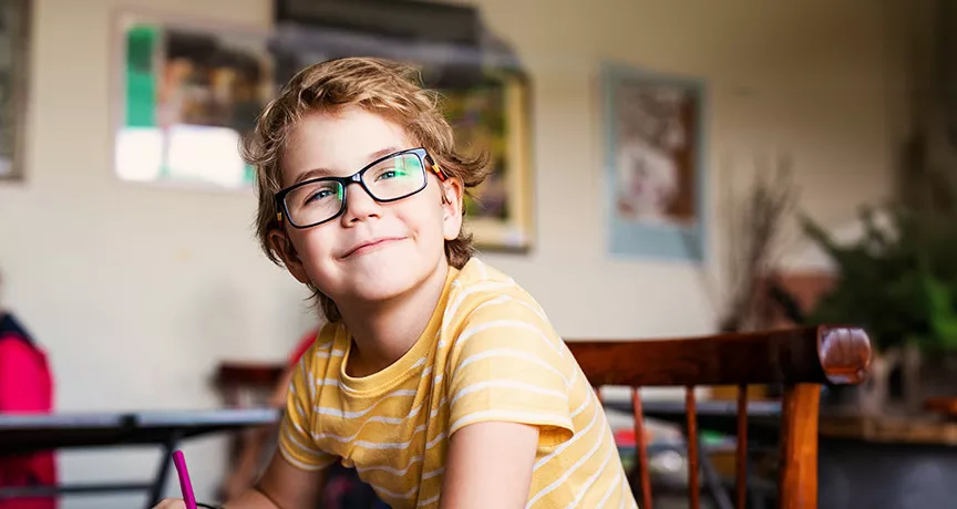 dítě s brýlemi v lavici na základní škole