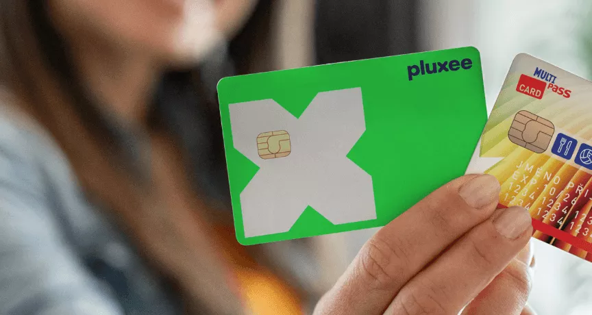 Ruka držící plastové benefitní karty Pluxee a Sodexo