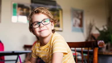 dítě s brýlemi v lavici na základní škole